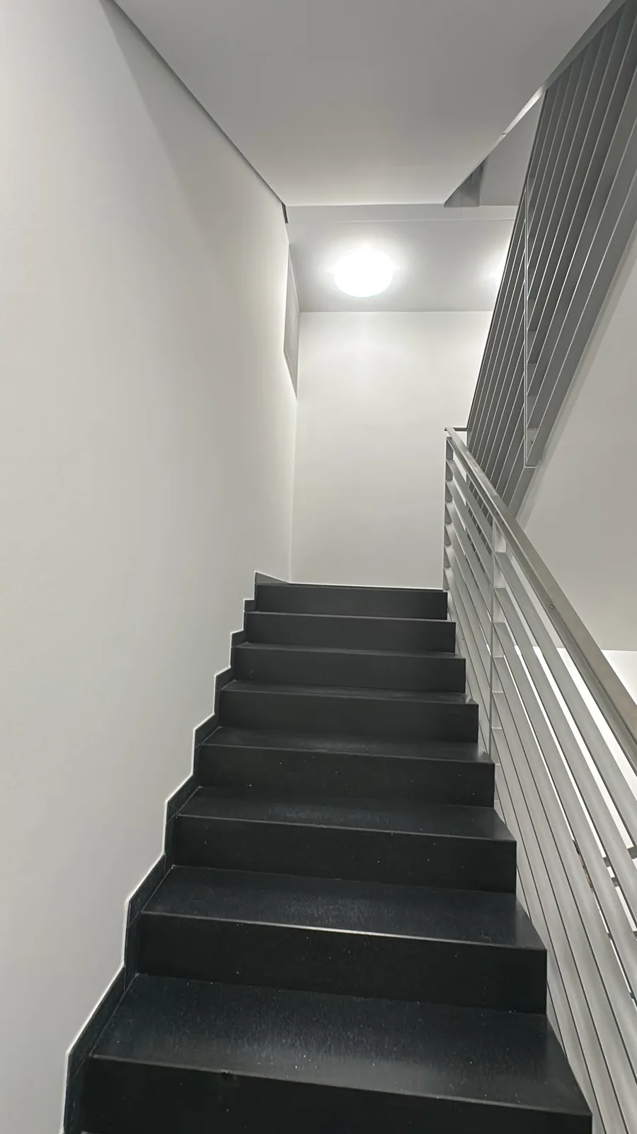 Moderne schwarze Treppe mit Metallgeländer
